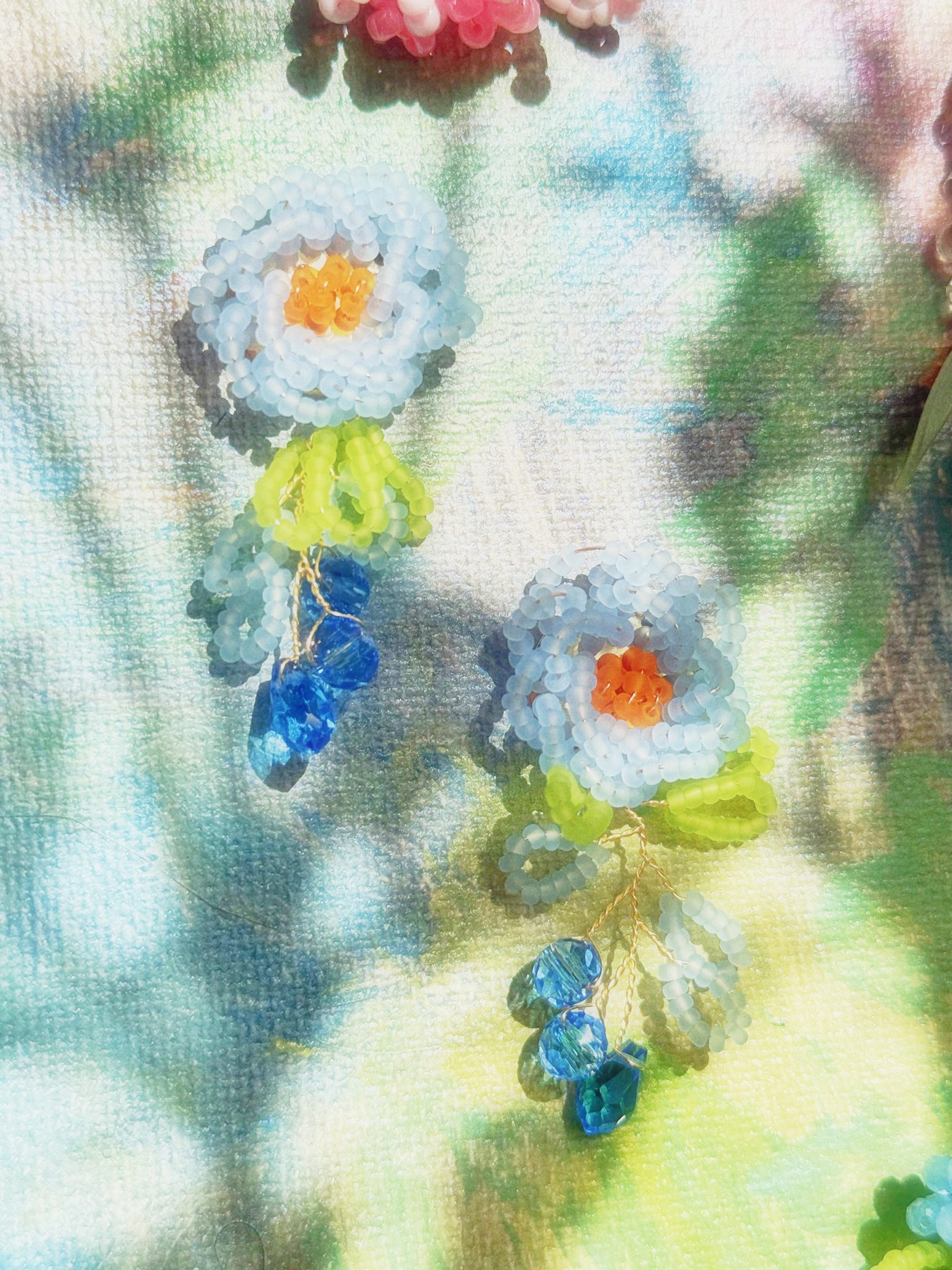 White daisy earrings with green leaves and blue drops