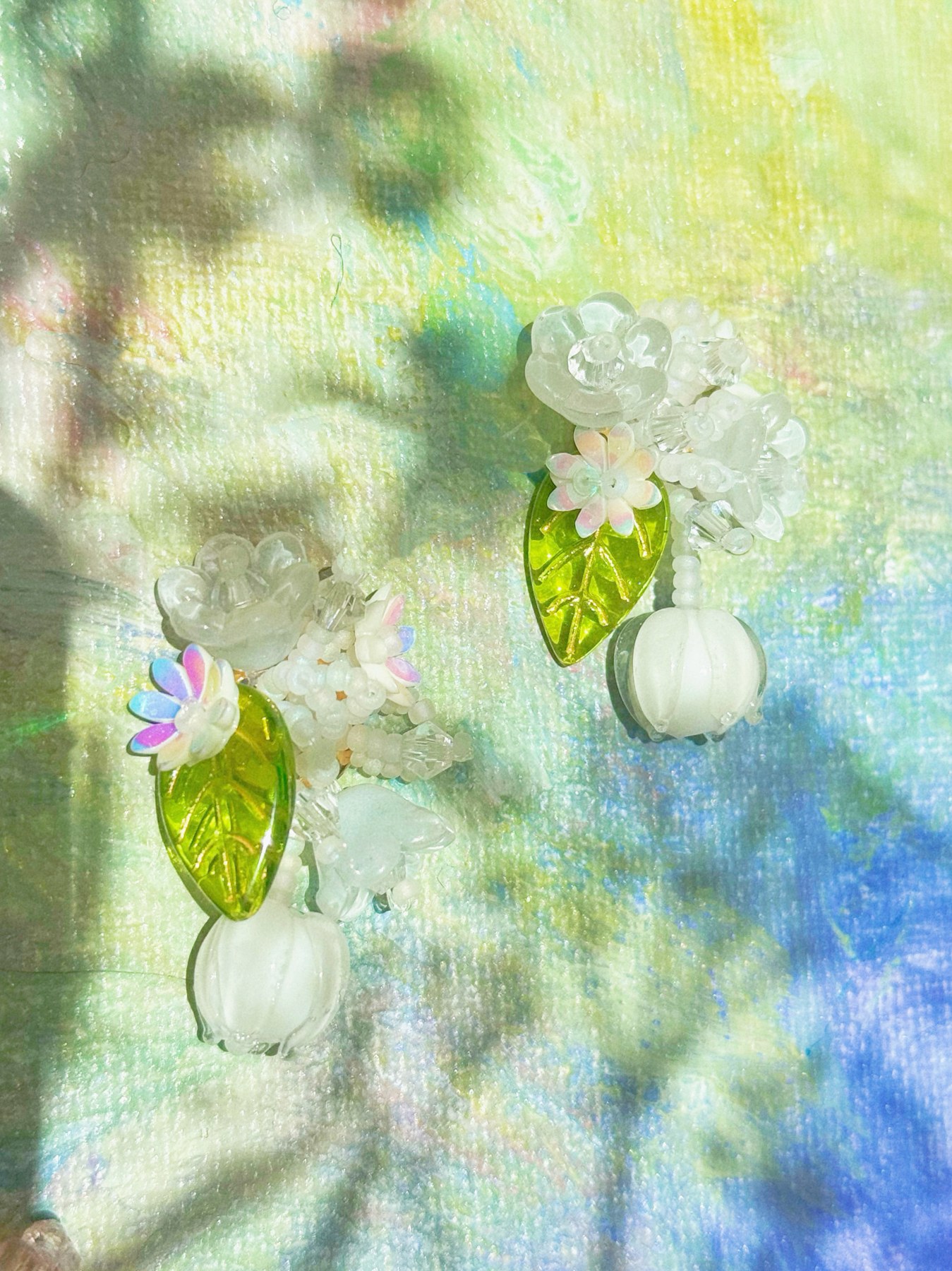 White flower earrings with fresh green leaf details