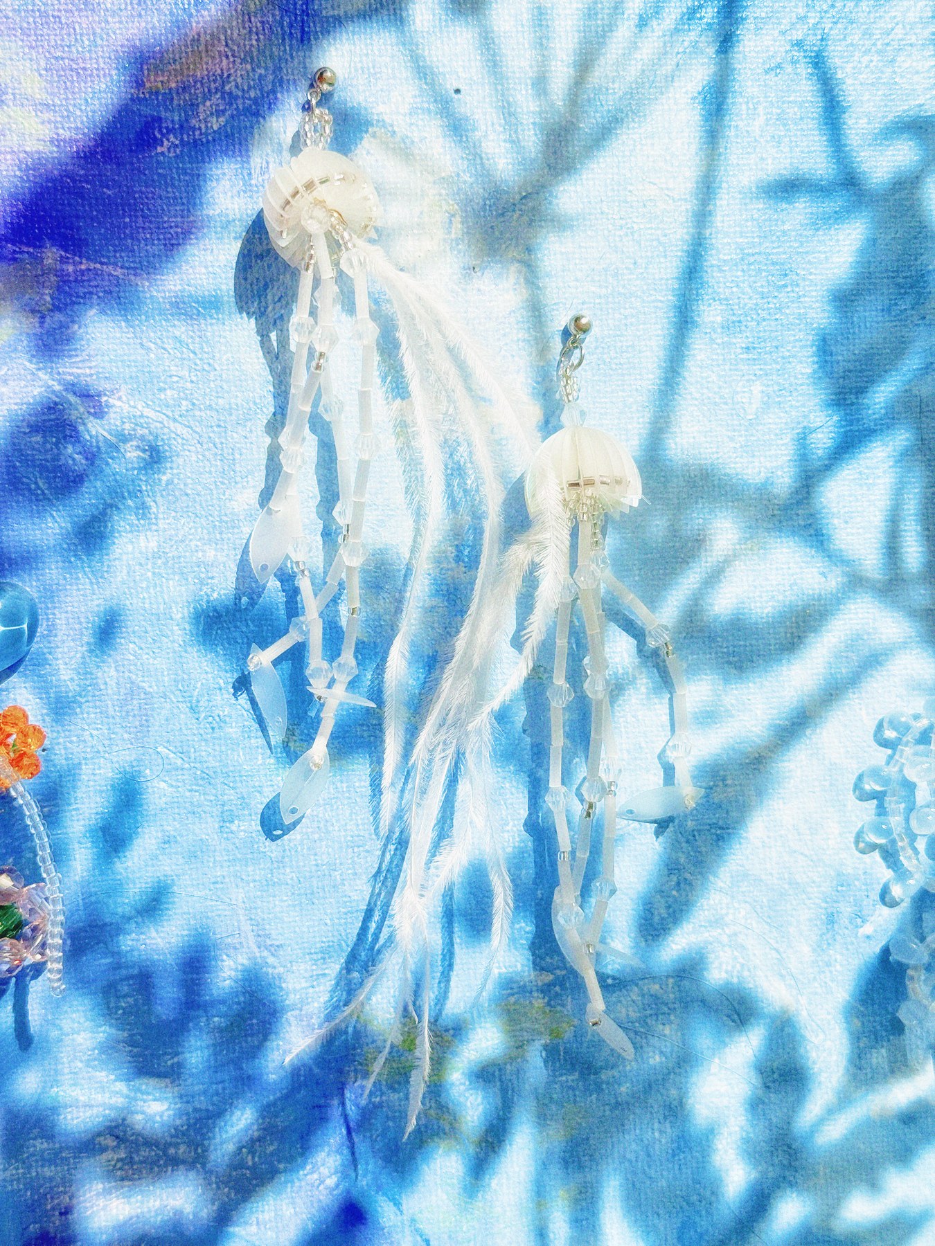 Silver branch-shaped earrings against a blue background