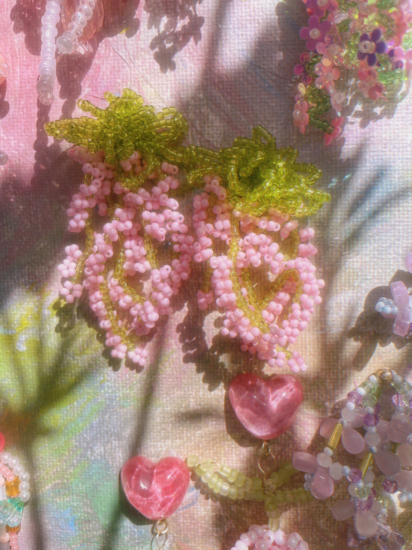 Pink beaded flower earrings with green foliage