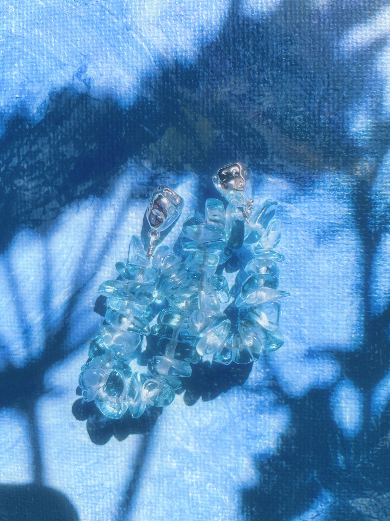 Pale blue translucent beaded earrings in sunlight