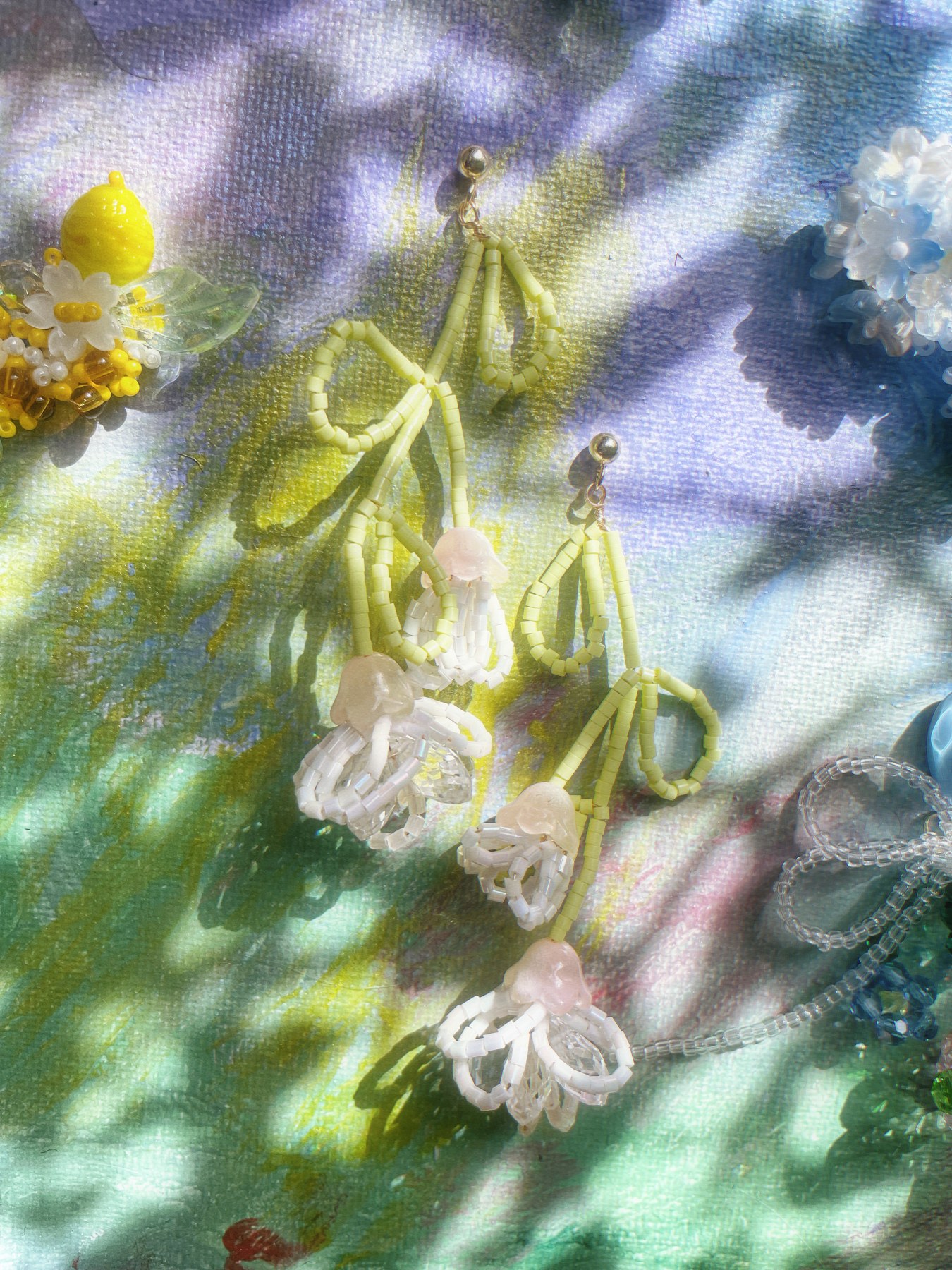 Delicate pale flower earrings on long green stems