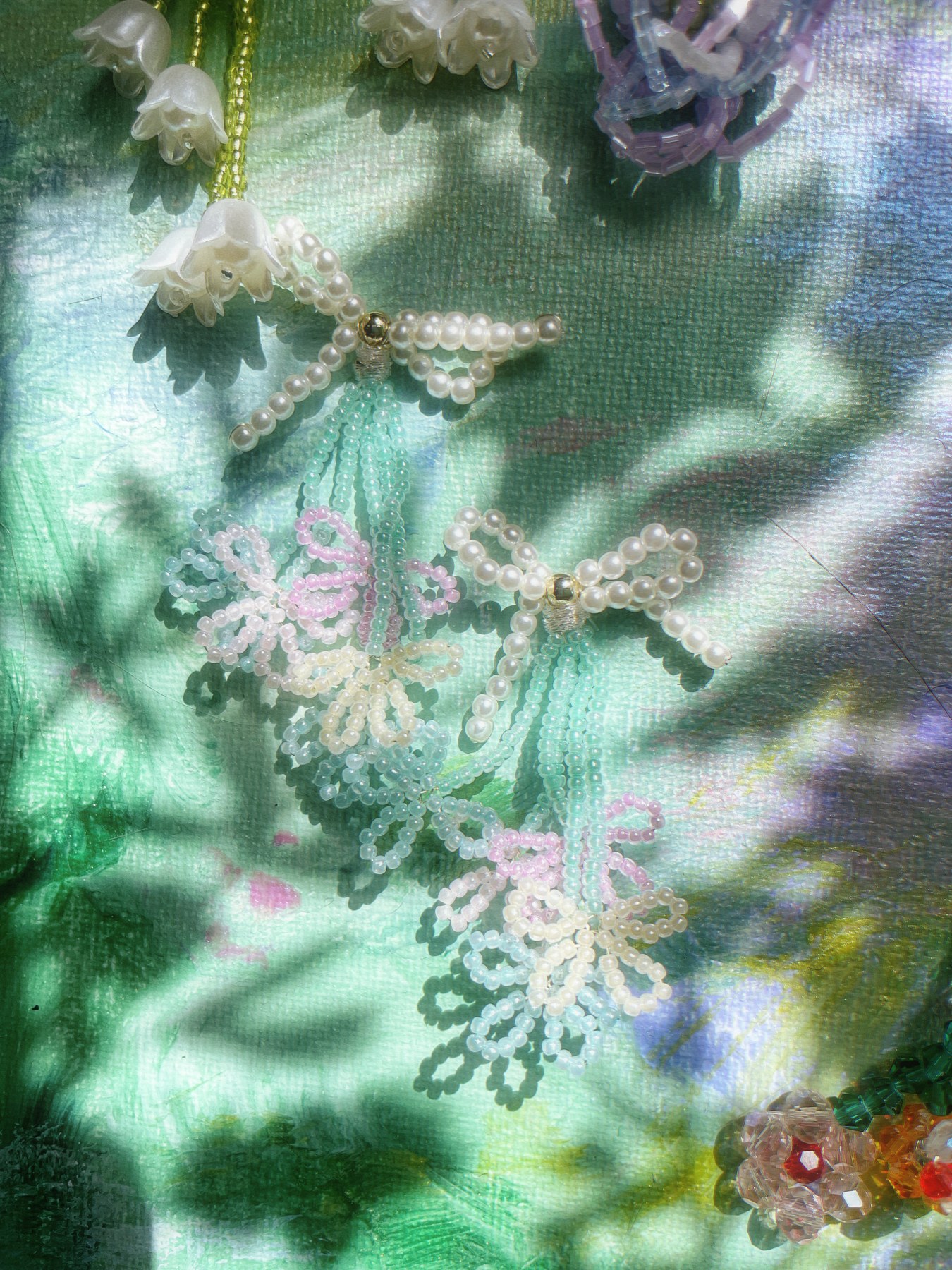 White lace-like flower earrings against a green background