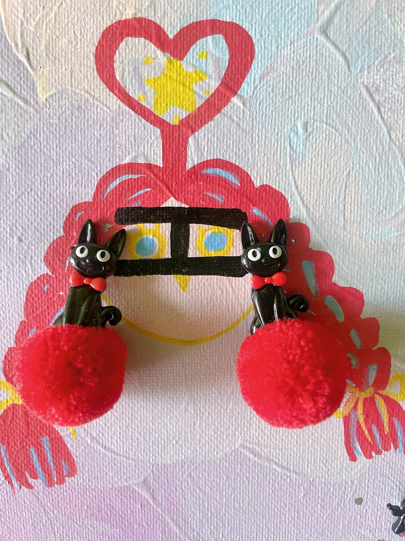 Red character-inspired earrings with heart details