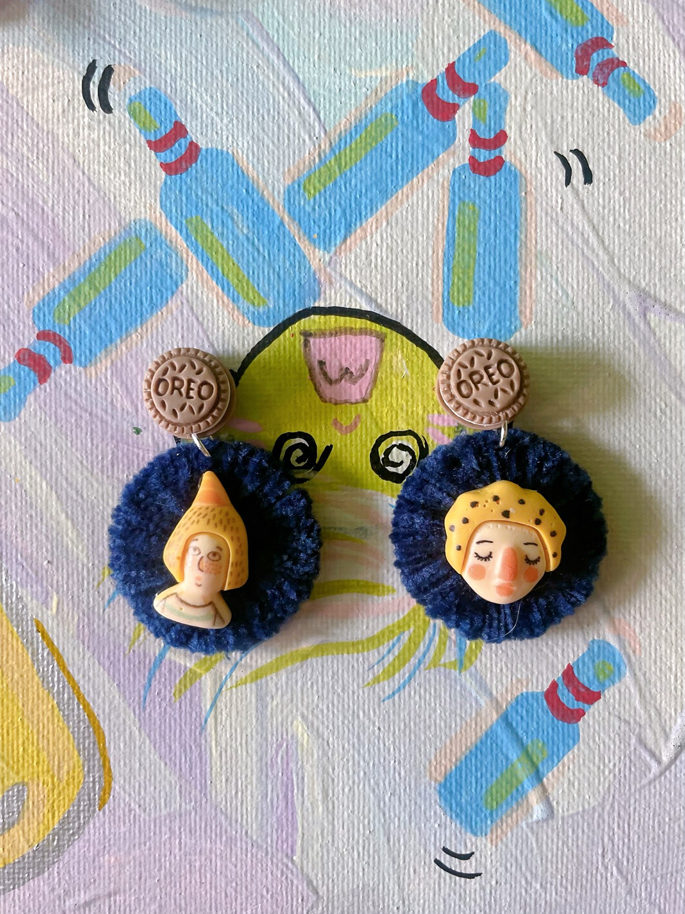 Blue and yellow character-inspired earrings with decorative charms